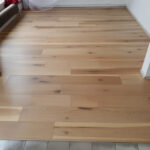 Rénovation d’un salon d'un appartement à Saint Génies des Mourgues par Reno'Zen avec remplacement du carrelage par un parquet flottant bois sur isolant acoustique